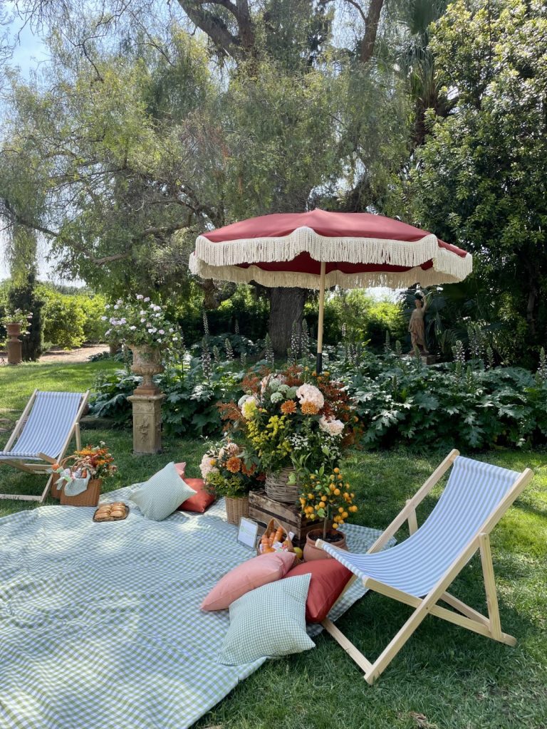 Decoración de picnic exclusivo  al aire libre con sombrillas y sillas elegantes en Huerto de San Vicente, Valencia